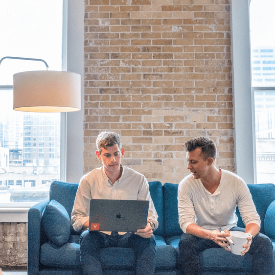 Two men collaborating on social media marketing strategies in a modern office setting.