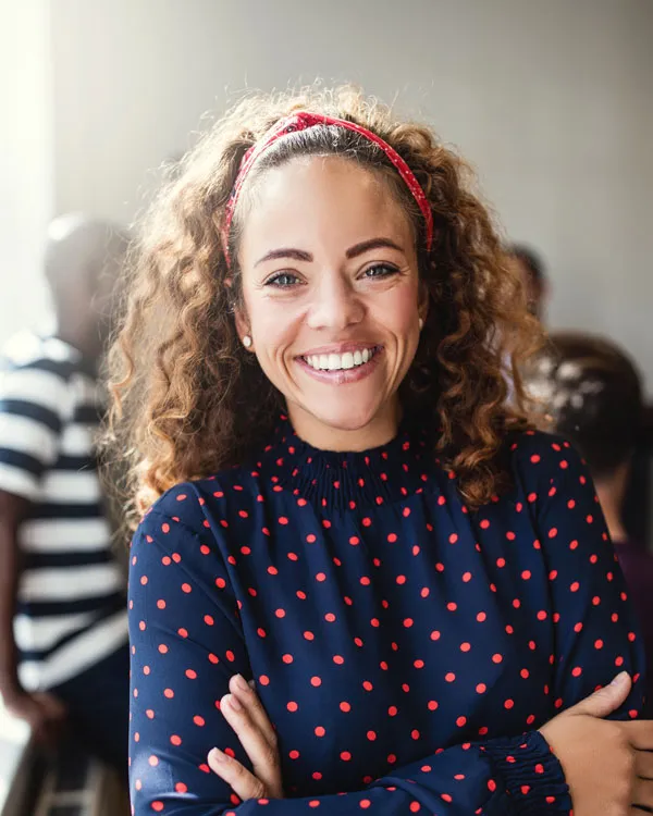 smiling designer in an office with colleagues in t 7ARX2JM